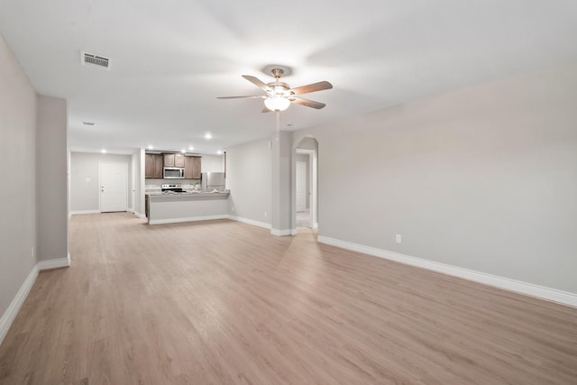 6230 El Cobre Dr, Houston, TX 77048 - unfurnished living room with light wood-type flooring, baseboards, ceiling fan, arched walkways, and recessed lighting