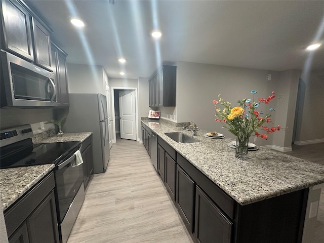 6230 El Cobre Dr, Houston, TX 77048 - kitchen featuring stainless steel appliances, a sink, a peninsula, light stone counters, and recessed lighting