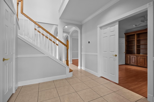 2350 Hawk Mdws, Pearland, TX 77581 - foyer entrance with crown molding, arched walkways, light tile patterned floors, stairway, and baseboards