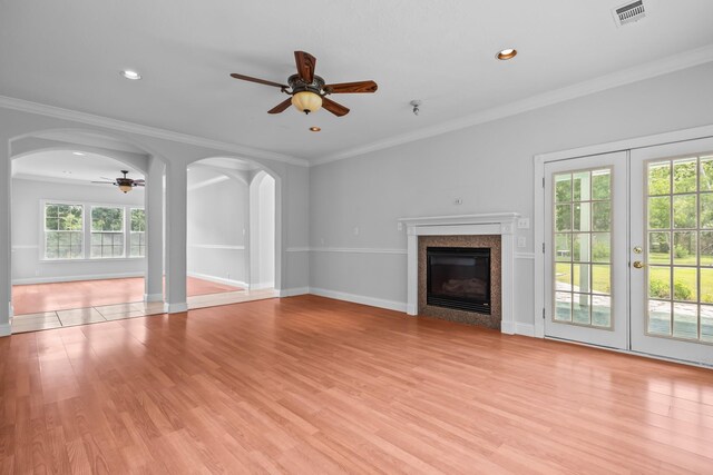 2350 Hawk Mdws, Pearland, TX 77581 - unfurnished living room with ceiling fan, healthy amount of natural light, light wood-style floors, a glass covered fireplace, and crown molding