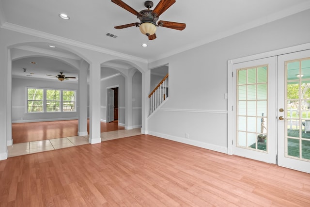 2350 Hawk Mdws, Pearland, TX 77581 - unfurnished living room featuring ceiling fan, healthy amount of natural light, arched walkways, ornamental molding, and light wood-style flooring