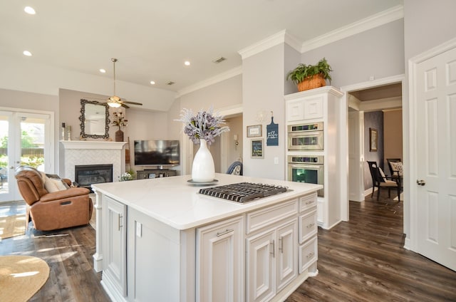7 Champion Villa Dr, Houston, TX 77069 - kitchen with a tiled fireplace, ceiling fan, dark wood finished floors, open floor plan, and white cabinetry