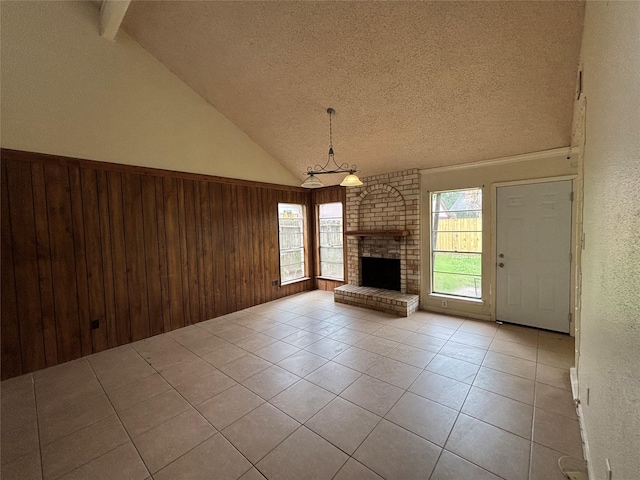 5506 Cactus Forest Dr, Houston, TX 77088 - unfurnished living room with tile patterned flooring, lofted ceiling, a textured ceiling, wood walls, and a brick fireplace