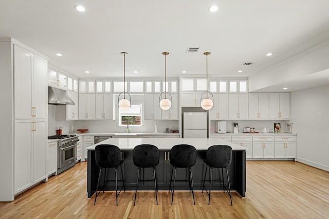 5630 Lymbar Dr, Houston, TX 77096 - kitchen featuring stainless steel appliances, under cabinet range hood, a kitchen island, light countertops, and white cabinets