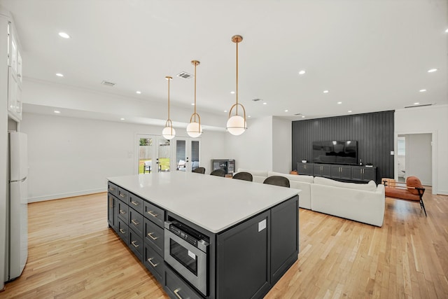 5630 Lymbar Dr, Houston, TX 77096 - kitchen with freestanding refrigerator, light wood-type flooring, a center island, light countertops, and recessed lighting