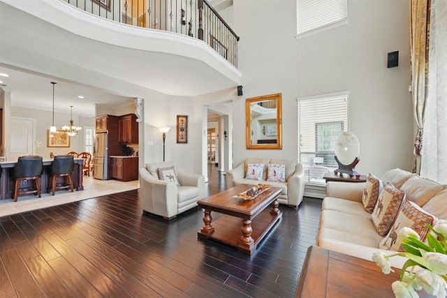 2915 Sentry Oak Way, Sugar Land, TX 77479 - living area featuring a chandelier, plenty of natural light, a towering ceiling, and wood finished floors