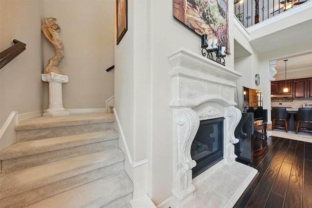 2915 Sentry Oak Way, Sugar Land, TX 77479 - staircase featuring wood finished floors, a fireplace, and a high ceiling