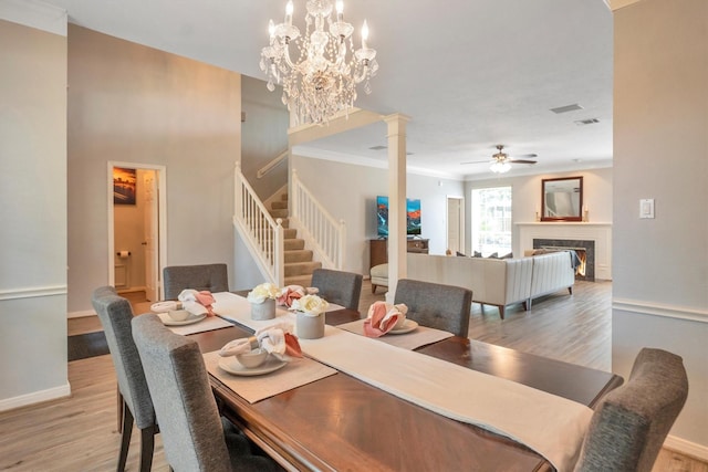7318 Starbridge Dr, Houston, TX 77095 - dining room with stairway, a ceiling fan, light wood-style floors, ornate columns, and crown molding