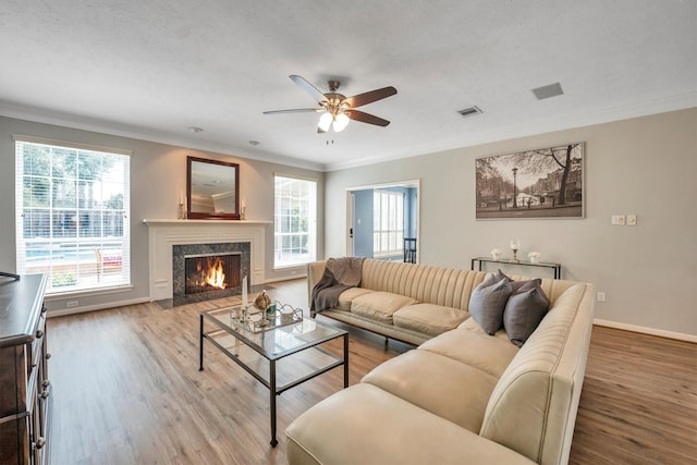 7318 Starbridge Dr, Houston, TX 77095 - living room featuring a ceiling fan, healthy amount of natural light, wood finished floors, a fireplace, and crown molding