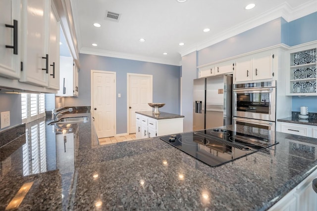 7318 Starbridge Dr, Houston, TX 77095 - kitchen featuring appliances with stainless steel finishes, a sink, a center island, white cabinetry, and dark stone countertops