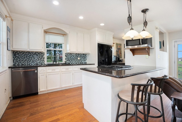 4201 Lawrence Rd, Beach City, TX 77523 - kitchen with black appliances, light wood-style floors, white cabinets, plenty of natural light, and recessed lighting