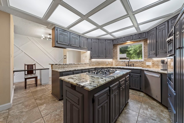 489 Merrimac Park, Conroe, TX 77302 - kitchen with appliances with stainless steel finishes, decorative backsplash, a sink, a peninsula, and a center island