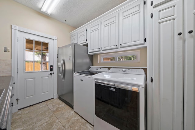 489 Merrimac Park, Conroe, TX 77302 - laundry area featuring independent washer and dryer, cabinet space, and a textured ceiling