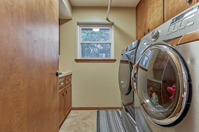660 Hillcrest Dr, Huntsville, TX 77340 - laundry area featuring cabinet space, washing machine and dryer, light tile patterned flooring, and baseboards