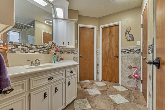 660 Hillcrest Dr, Huntsville, TX 77340 - full bath with vanity, a textured ceiling, tile walls, a shower with door, and stone finish flooring