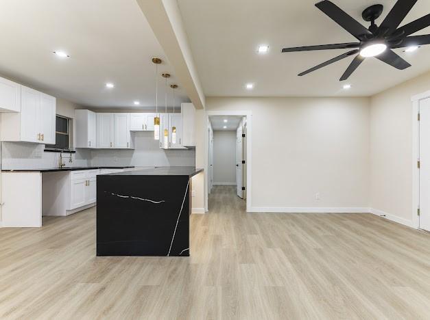 1848 Kipling St, Liberty, TX 77575 - kitchen featuring light wood-type flooring, recessed lighting, white cabinetry, open floor plan, and dark countertops