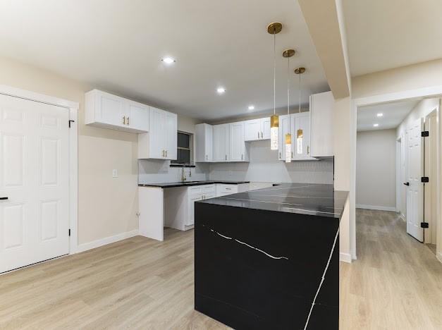 1848 Kipling St, Liberty, TX 77575 - kitchen with light wood-type flooring, white cabinets, baseboards, and recessed lighting