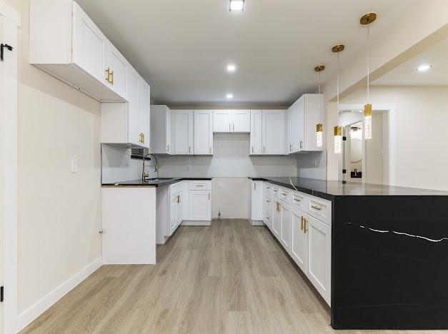 1848 Kipling St, Liberty, TX 77575 - kitchen with light wood-style floors, dark countertops, tasteful backsplash, and recessed lighting