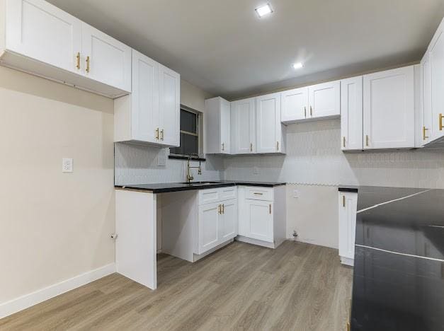 1848 Kipling St, Liberty, TX 77575 - kitchen with light wood-style flooring, a sink, decorative backsplash, white cabinetry, and recessed lighting