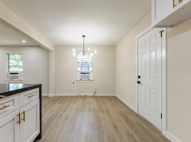 1848 Kipling St, Liberty, TX 77575 - unfurnished dining area featuring light wood-style floors, a chandelier, baseboards, recessed lighting, and cooling unit