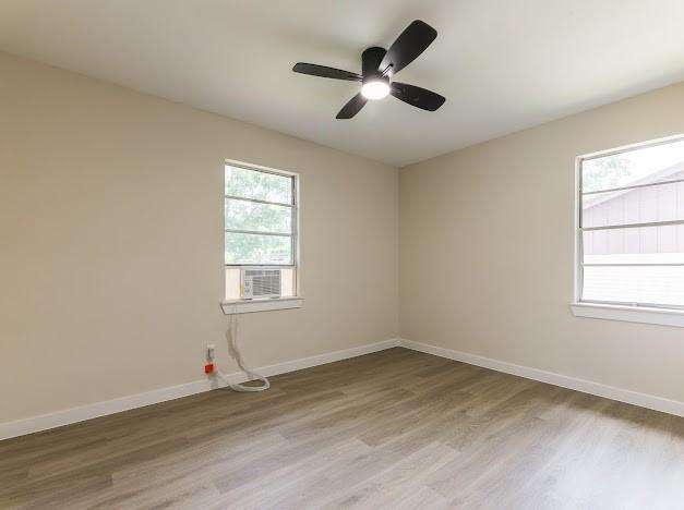 1848 Kipling St, Liberty, TX 77575 - unfurnished room with light wood finished floors, baseboards, ceiling fan, and cooling unit