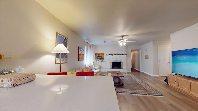 9723 Dalmally St, Spring, TX 77379 - living area with wood finished floors, a ceiling fan, a fireplace, and baseboards