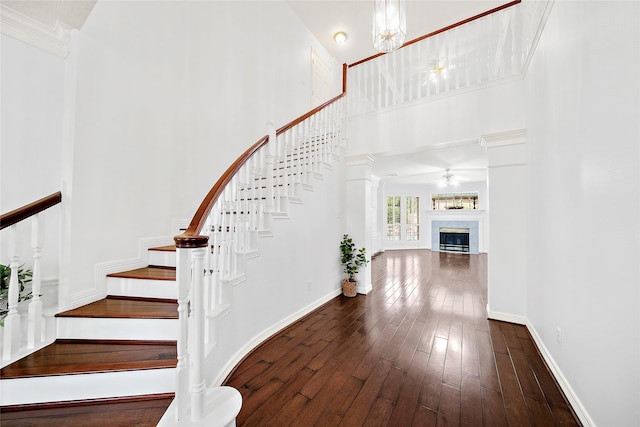 1930 Hollys Way, Sugar Land, TX 77479 - stairs with a towering ceiling, hardwood / wood-style flooring, a fireplace, ceiling fan, and baseboards