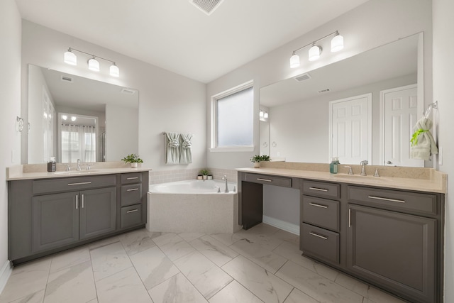27130 Spanish Wind Ct, Magnolia, TX 77354 - bathroom featuring plenty of natural light, two vanities, a garden tub, and marble finish flooring