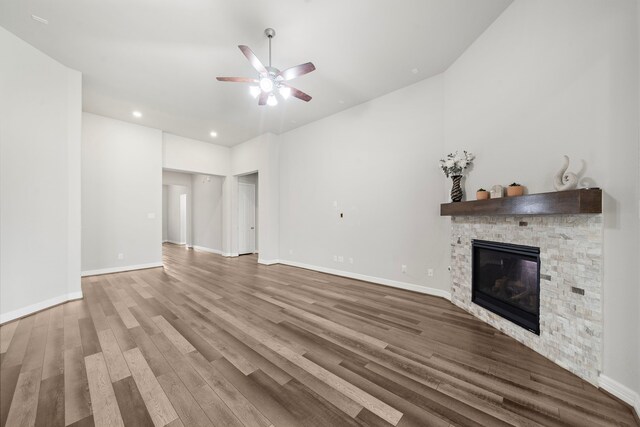 27130 Spanish Wind Ct, Magnolia, TX 77354 - unfurnished living room with a ceiling fan, a stone fireplace, wood finished floors, recessed lighting, and baseboards