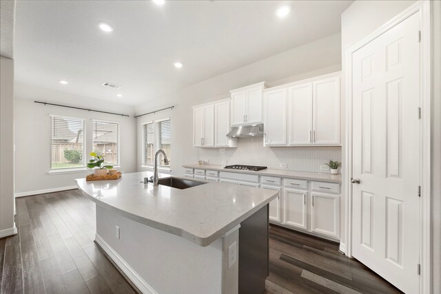 27130 Spanish Wind Ct, Magnolia, TX 77354 - kitchen featuring a sink, under cabinet range hood, stainless steel gas stovetop, dark wood-style flooring, and recessed lighting