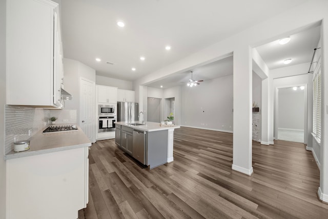 27130 Spanish Wind Ct, Magnolia, TX 77354 - kitchen with appliances with stainless steel finishes, a sink, tasteful backsplash, light countertops, and dark wood finished floors