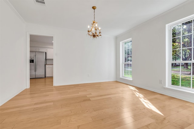 13631 Balmore Cir, Houston, TX 77069 - spare room featuring a chandelier, plenty of natural light, crown molding, and light wood-style flooring