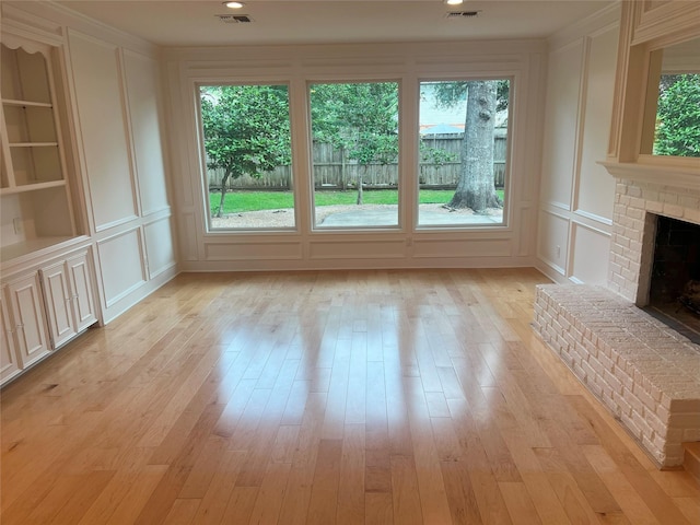 13631 Balmore Cir, Houston, TX 77069 - unfurnished living room featuring a decorative wall, plenty of natural light, built in features, a fireplace, and ornamental molding