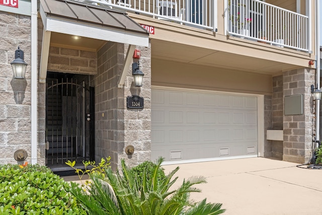 1304 Veranda Mist, League City, TX 77573 - entrance to property with a balcony, a garage, driveway, and stone siding