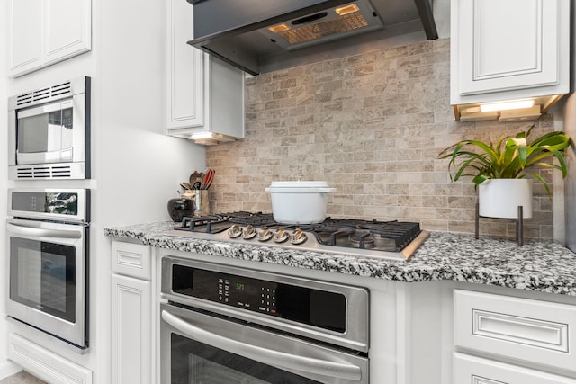 1304 Veranda Mist, League City, TX 77573 - kitchen with stainless steel appliances, under cabinet range hood, tasteful backsplash, and white cabinetry