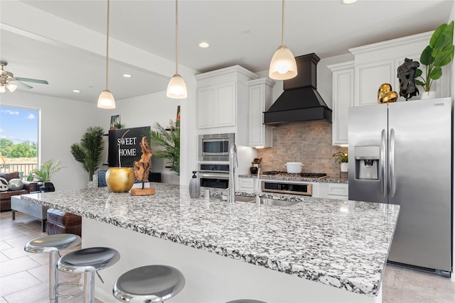 1304 Veranda Mist, League City, TX 77573 - kitchen featuring stainless steel appliances, premium range hood, decorative backsplash, white cabinets, and recessed lighting