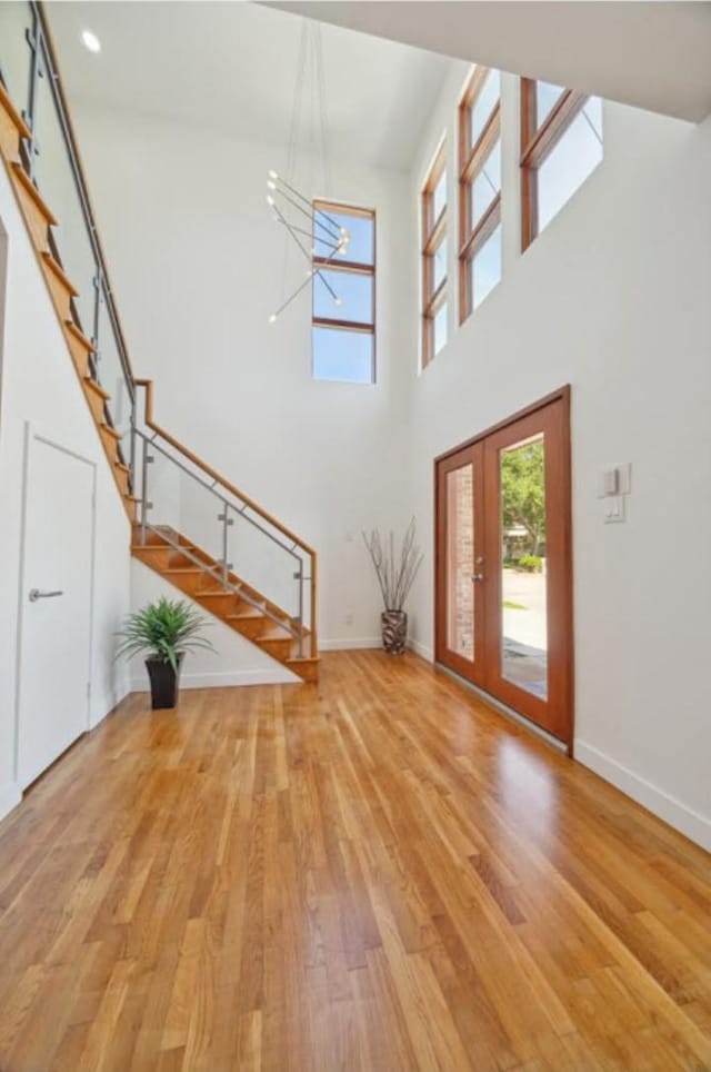 8003 Harbor Point Dr, Houston, TX 77071 - entryway featuring stairs, plenty of natural light, light wood-type flooring, baseboards, and a towering ceiling