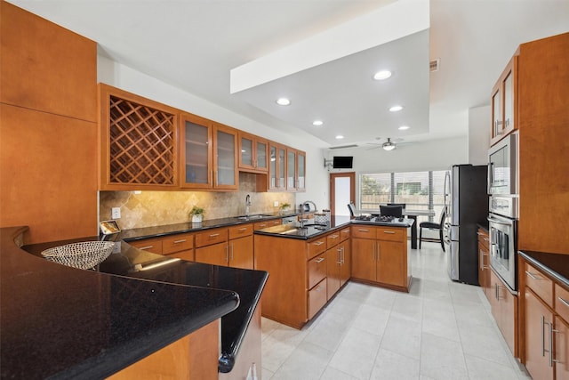 8003 Harbor Point Dr, Houston, TX 77071 - kitchen with appliances with stainless steel finishes, brown cabinets, backsplash, recessed lighting, and glass insert cabinets