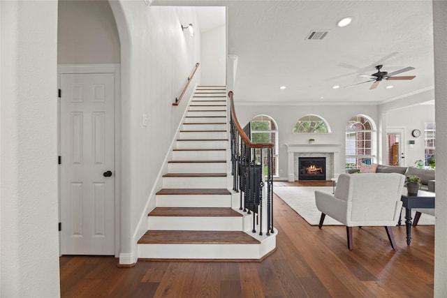 18818 Cypress Chateau Dr, Spring, TX 77388 - staircase with wood finished floors, recessed lighting, a ceiling fan, baseboards, and a warm lit fireplace