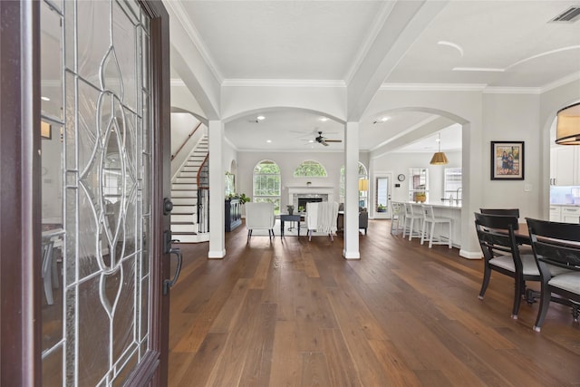 18818 Cypress Chateau Dr, Spring, TX 77388 - entrance foyer with a ceiling fan, arched walkways, wood finished floors, ornamental molding, and a fireplace