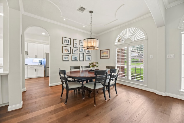 18818 Cypress Chateau Dr, Spring, TX 77388 - dining area featuring arched walkways, wood-type flooring, a chandelier, crown molding, and baseboards