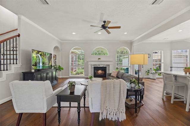 18818 Cypress Chateau Dr, Spring, TX 77388 - living room featuring ceiling fan, wood finished floors, a glass covered fireplace, ornamental molding, and stairway