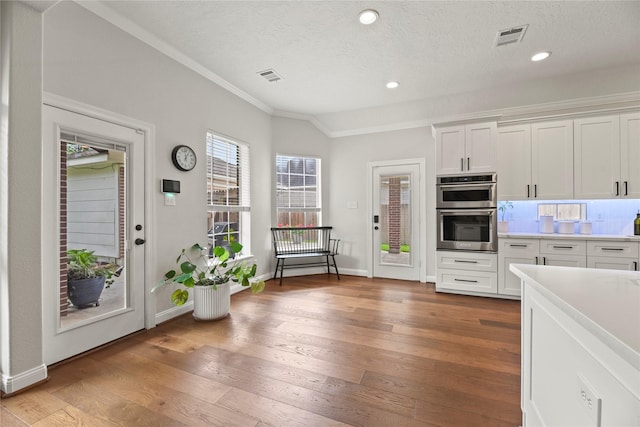 18818 Cypress Chateau Dr, Spring, TX 77388 - kitchen featuring stainless steel double oven, crown molding, light wood-type flooring, white cabinets, and a textured ceiling