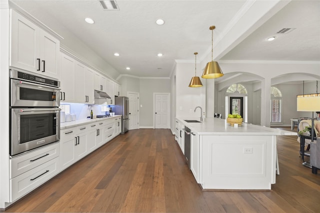 18818 Cypress Chateau Dr, Spring, TX 77388 - kitchen featuring appliances with stainless steel finishes, a sink, arched walkways, ornamental molding, and white cabinets