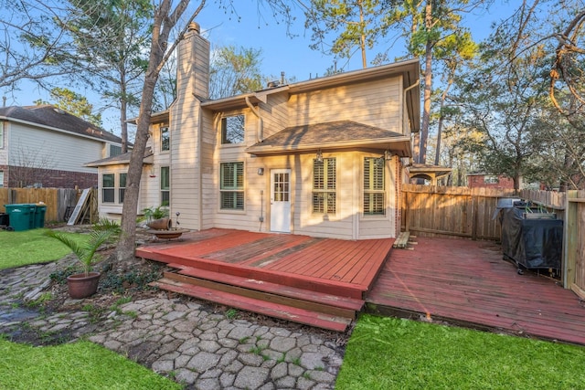 11 Snow Woods Ct, The Woodlands, TX 77385 - back of property featuring a fenced backyard, a chimney, and a deck