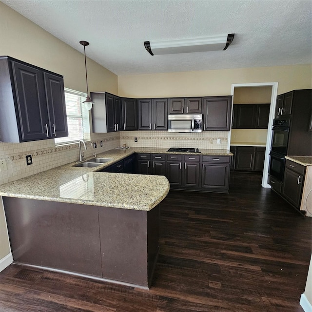 6118 Deep S Dr, Katy, TX 77449 - kitchen with a sink, stainless steel microwave, a peninsula, dark wood-type flooring, and light stone counters