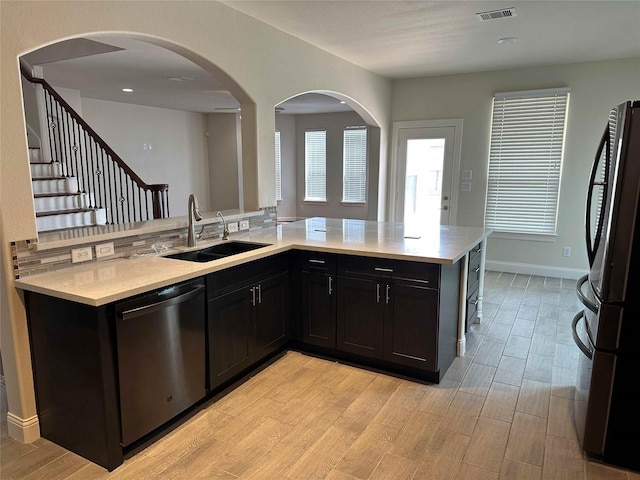 24811 Deep Coral Ct, Katy, TX 77494 - kitchen featuring stainless steel appliances, a sink, light wood-style flooring, and dark cabinetry