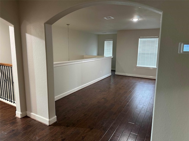 24811 Deep Coral Ct, Katy, TX 77494 - spare room featuring arched walkways, dark wood-style floors, and baseboards