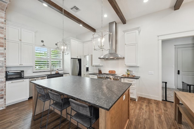 9343 Kai Dr, Beach City, TX 77523 - kitchen with appliances with stainless steel finishes, a sink, wall chimney exhaust hood, dark countertops, and beamed ceiling