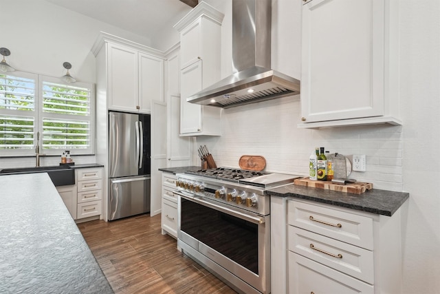 9343 Kai Dr, Beach City, TX 77523 - kitchen featuring stainless steel appliances, wall chimney exhaust hood, a sink, tasteful backsplash, and white cabinetry